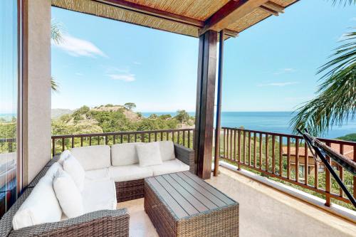 a balcony with a couch and a view of the ocean at Azul Paraiso 7B in Coco