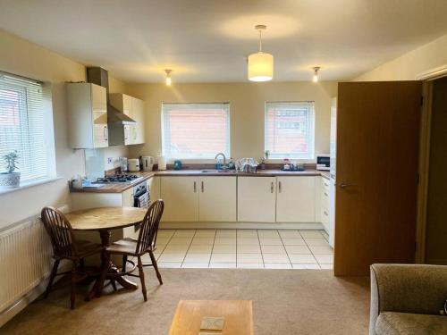 a kitchen with a table and chairs in a room at Spacious Ground Floor Flat in Buckinghamshire