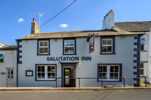 The Horse and Farrier Inn and The Salutation Inn Threlkeld Keswick في Threlkeld: مبنى فيه نزل خلاص على الشارع