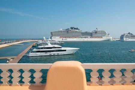 a balcony with boats in the water near a pier at Mina Hotel and Residences By The Torch in Doha