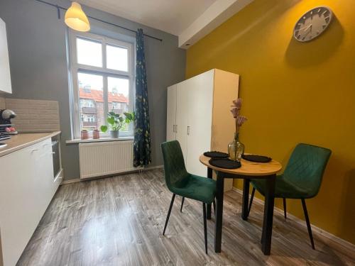 eine Küche mit einem Tisch und Stühlen sowie einem Kühlschrank in der Unterkunft Apartament Kościuszko in Kattowitz