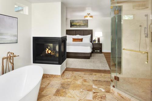 a bedroom with a fireplace and a bed and a tub at Kenwood Inn & Spa in Kenwood