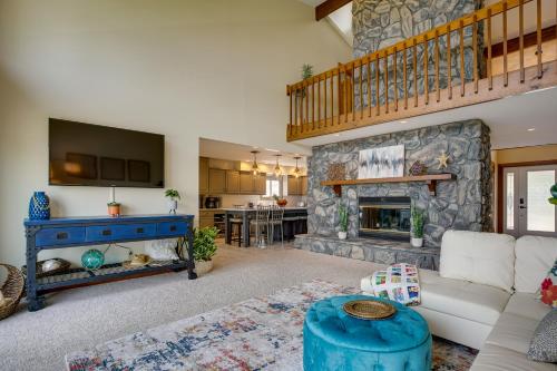 a living room with a large stone fireplace at Lakefront Syracuse Home with Deck and Private Dock! in Syracuse
