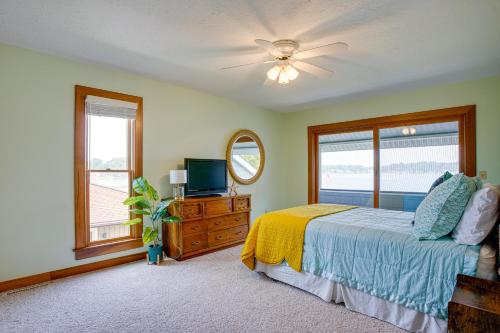 a bedroom with a bed and a tv and a window at Lakefront Syracuse Home with Deck and Private Dock! in Syracuse