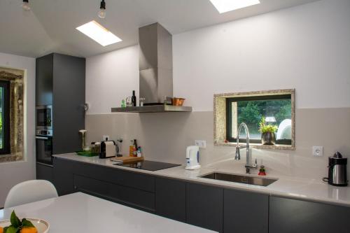 a kitchen with a sink and a counter at Quinta do Bairro in Vieira do Minho