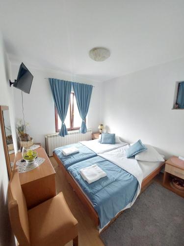 a bedroom with a bed and a table and a window at Rooms Putnik in Senj