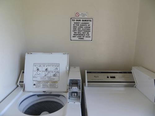 a small bathroom with a toilet with a sign on the wall at Americas Best Value Inn Loma Lodge in San Diego