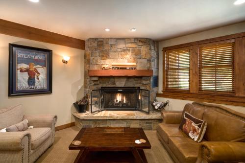 a living room with a stone fireplace in a house at The Porches in Steamboat Springs