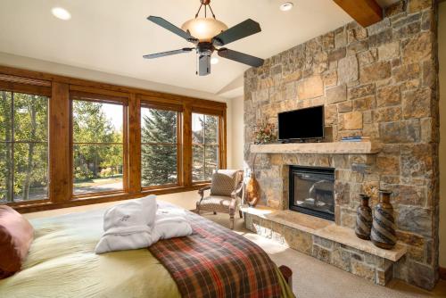 a bedroom with a stone wall with a bed and a fireplace at The Porches in Steamboat Springs