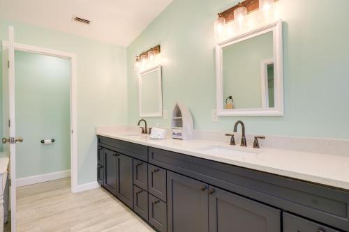 a bathroom with two sinks and a large mirror at Waterfront Jacksonville Retreat with Boat Dock! in Jacksonville