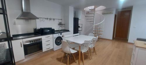 una cucina con tavolo e sedie bianchi e una scala a chiocciola di SanFernando14 ad Alicante