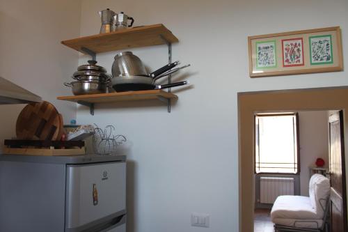 a kitchen with a refrigerator and shelves on the wall at Casa Di Borgo in Todi