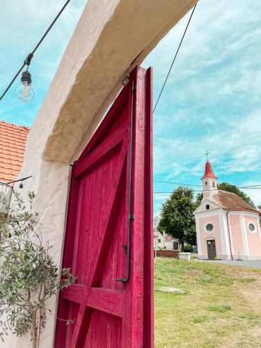 a red door on the side of a building with a church at Penzion U Kapličky in Znojmo