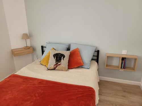 a bedroom with a bed with a dog on the pillows at cosy, spacieux, avec balcon, au calme in Artigues-près-Bordeaux