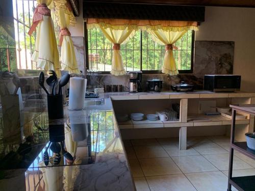 a kitchen with yellow drapes and a counter with a sink at Villa Ali Río Cuarto in Río Cuarto