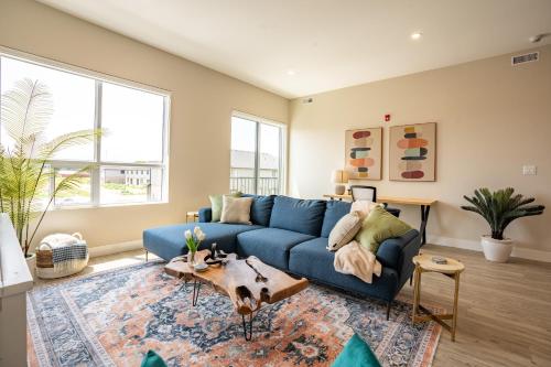 a living room with a blue couch and a table at Brand New and Very Spacious 1 Bedroom Condo! in Chatham