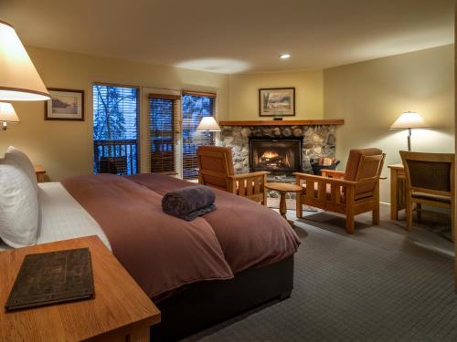 1 dormitorio con 1 cama grande y chimenea en Emerald Lake Lodge, en Field