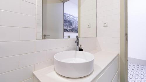 a white bathroom with a sink and a mirror at Central Stunning Duplex w/ Patio by LovelyStay in Porto