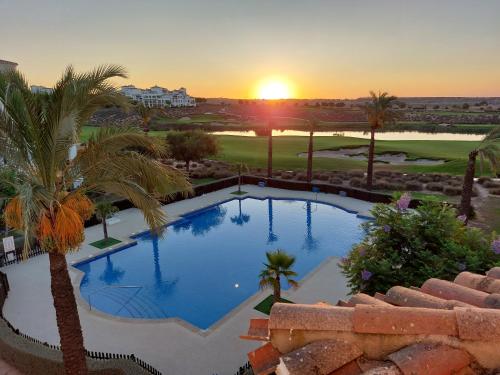 a swimming pool with a sunset in the background at La Casa Mima Penthouse at Hacienda Riquelme in Sucina