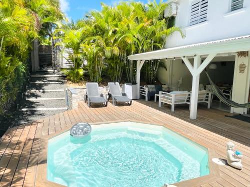 a swimming pool on a deck with a house at Résidence Ti Gwapabe, proche raisins clairs in Saint-François