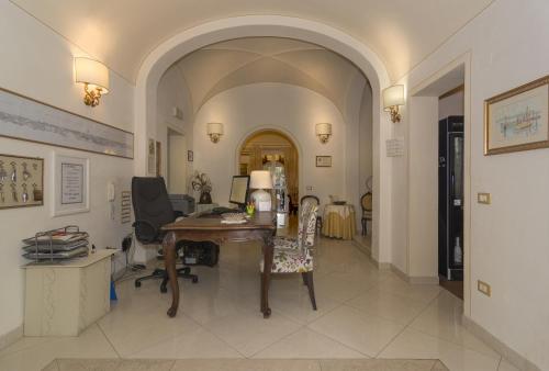 a hallway with a desk and chairs in a room at Il Mattino Ha L'Oro In Bocca in Pisa
