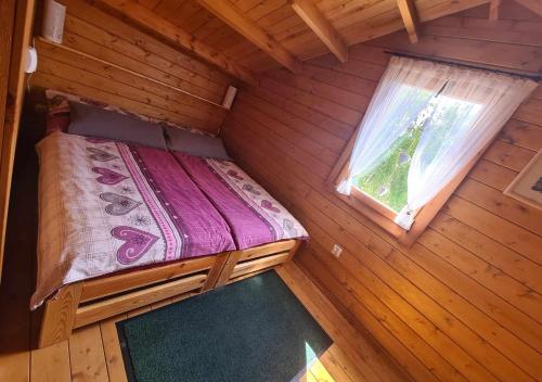 widok na łóżko w drewnianej kabinie w obiekcie Leśna Chatka w Kłodzku