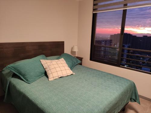 een slaapkamer met een bed en uitzicht op de stad bij ¡Comodísimo y práctico depto! in Santiago