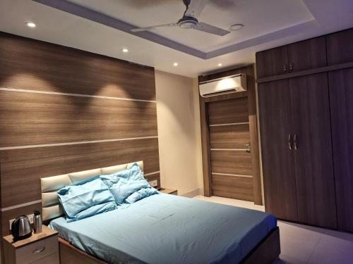 Mavenoak Dreams B&B في كولْكاتا: غرفة نوم بسرير وجدار خشبي