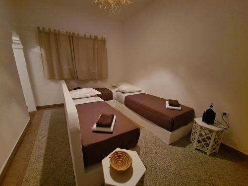ein Hotelzimmer mit 2 Betten und einem Tisch in der Unterkunft La Maison des Vagues in Sidi Kaouki