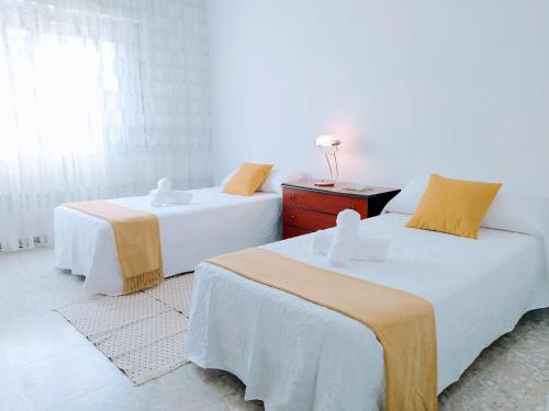 two beds in a room with white walls at Alojamiento Caldas Centro in Caldas de Reis