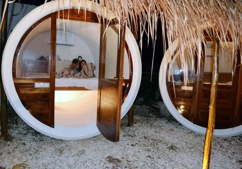 a group of people laying in a bed in front of a mirror at Kakao Cobá Hotel & Cenote Experience in Cobá