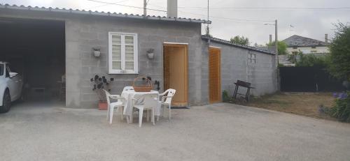 uma mesa e cadeiras em frente a uma casa em VILLA ELSA em Foz