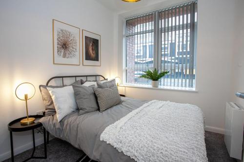 1 dormitorio con cama y ventana en Modern 2 Bedroom Apartment in Bolton en Bolton