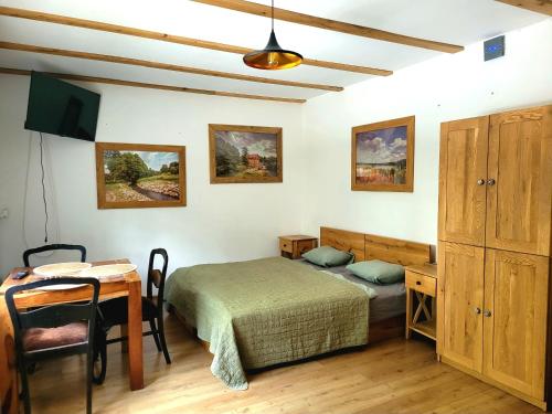 a bedroom with a bed and a desk and a table at Folwark Wierzchy in Wierzchy