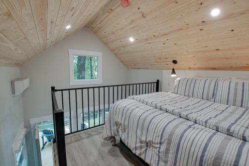 a bedroom with a bed and a balcony at Oak Luxury Treehouse near Lake Guntersville in Scottsboro