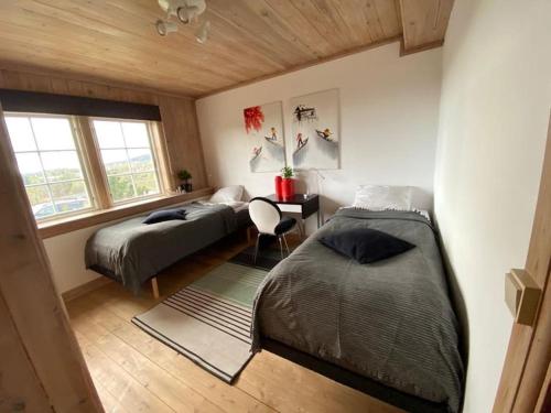 a bedroom with two beds and a desk with a chair at La Casa Nostra in Asker, only 17 minutes to Oslo in Asker