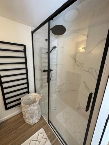 une salle de bain avec une douche avec une porte vitrée dans l'établissement Maison rénovée proche des plages, à Sète