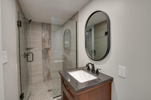 a bathroom with a sink and a shower with a mirror at 6 Pine Luxury Treehouse near Lake Guntersville in Scottsboro