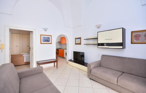 Una sala de estar con un sofá y un televisor. en Casa Tosally, en Ostuni