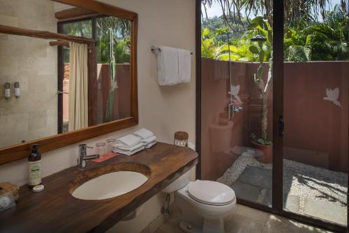 y baño con lavabo, aseo y espejo. en Punta Islita Villas Luxury Destination, en Islita