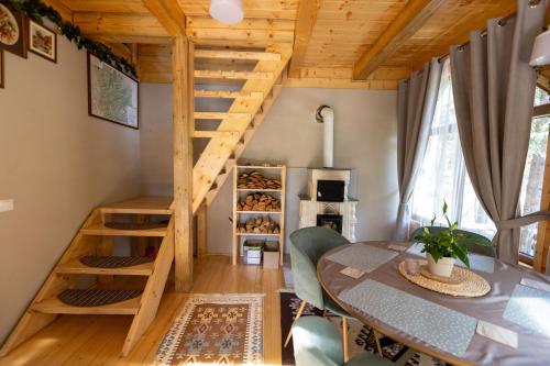 a dining room with a table and a staircase at Pura Vida Forest Home in Poiana Horea