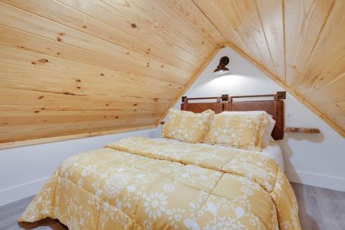 Schlafzimmer mit einem Bett mit Holzdecke in der Unterkunft 15 Daisy Tiny Cottage Near Lake Guntersville in Scottsboro