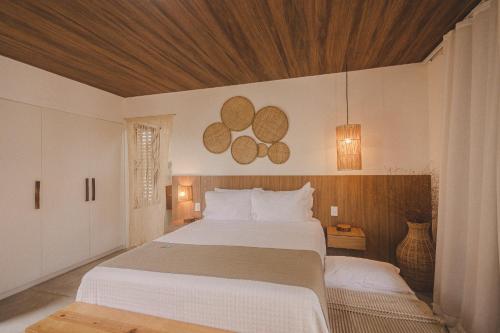 a bedroom with two beds and a wooden ceiling at Pousada Corália in São Miguel dos Milagres