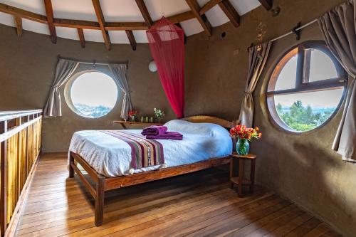 a bedroom with a bed in a room with windows at Casa Samai Boutique in Samaipata