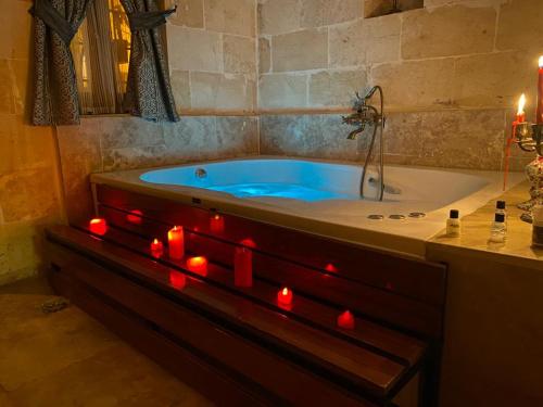 a bathroom with a tub with red candles in it at BABIL ANTIQUE HOTEL in Sanlıurfa