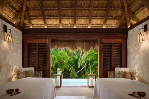 two beds in a room with a view of the ocean at Chablé Maroma in Playa del Carmen