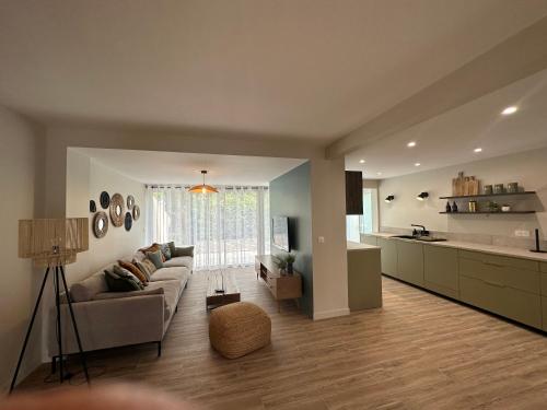 un salon avec un canapé et une cuisine dans l'établissement Maison rénovée proche des plages, à Sète