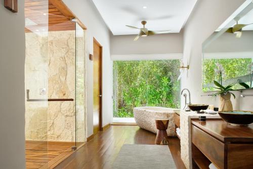 a bathroom with a tub and a large window at Chablé Maroma in Playa del Carmen