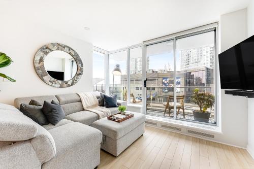 a living room with a couch and a large window at Heart of Downtown 1 bd Entire Condo - Pool, Gym, Parking, Office, AC in Vancouver