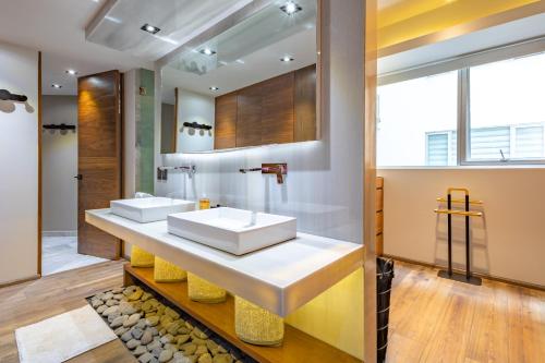 a bathroom with two sinks and a large mirror at 2floors luxury apartment condesa in Mexico City